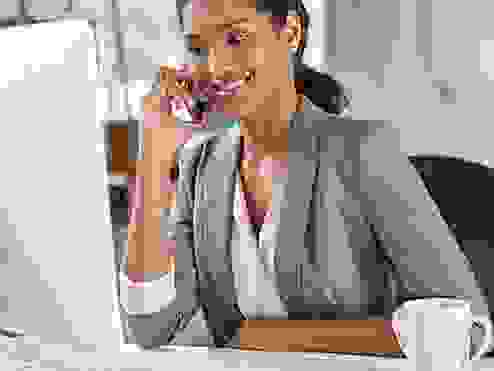 a business women having a call looking at her computer